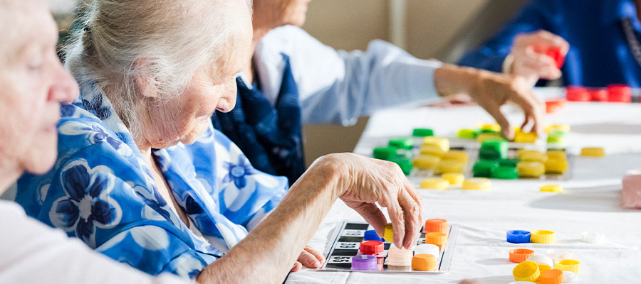 Senior citizens play bingo with colorful pieces